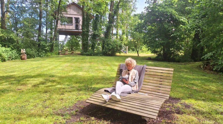 Mit Tablet auf dem Waldsofa im Waldbad – Arbeiten inmitten der Natur bei der Workation an der Nordsee.